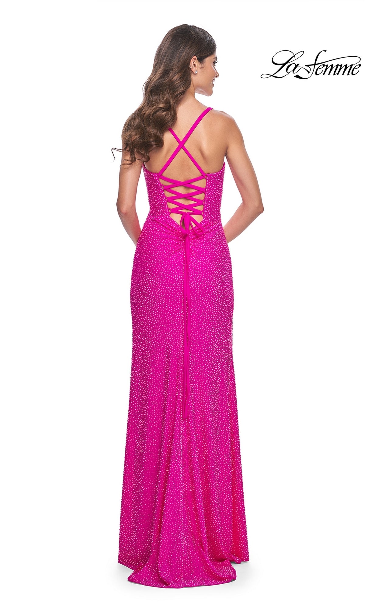 A woman wearing the La Femme Square-Neck Long Beaded Prom Dress 32058—an elegant, bright pink gown with a sleeveless silhouette, lace-up criss-cross back, slight train, and subtle sparkling beaded texture.